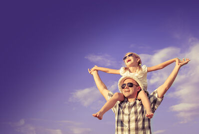 child on dads shoulders